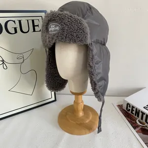 Detail of gray winter trapper hat with warm faux fur lining and brand logo patch
