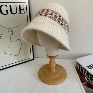 Detail view of Fair Isle knit bucket hat with geometric patterns on a wooden stand