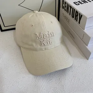 Dettaglio ravvicinato del cappellino di cotone beige con ricamo professionale Main Kit