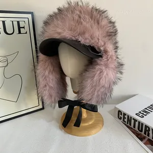 Dettaglio colbacco in ecopelliccia rosa con visiera nera e fiocco decorativo