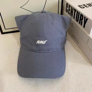 Detail of grey-blue baseball cap with cute 3D cat ears and white 'new' embroidery