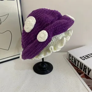 Dettaglio del berretto a fungo lavorato a mano in viola con pois bianchi e volant
