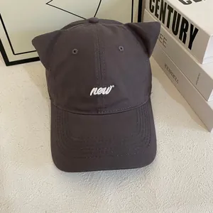 Cute dark grey baseball cap with cat ears and new embroidery on a white surface