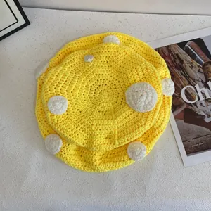 Dettaglio del berretto a fungo all'uncinetto giallo con trama a maglia fatta a mano e pois
