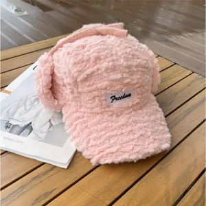 Détail du bonnet de baseball rose en laine d'agneau avec cache-oreilles et étiquette Freedom