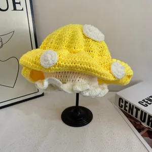 Dettaglio cappello a fungo all'uncinetto giallo con pois bianchi e bordo a balze