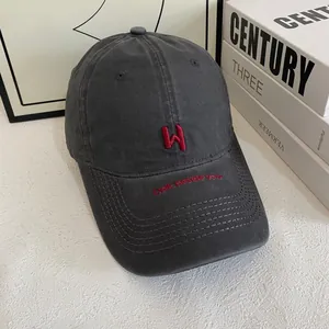 Close-up of charcoal cotton baseball cap with red W embroidery and walk beside you text
