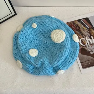 Dettaglio del cappello a fungo lavorato a maglia celeste con trama a pois all'uncinetto