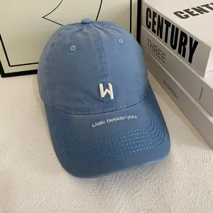 Detailed embroidery of white W letter and walk beside you text on navy cotton cap