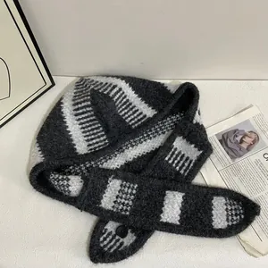 Détail de l'écharpe à capuche en tricot avec rayures et fermeture à bouton noir