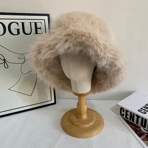 Primer plano de un gorro tipo pescador de piel sintética beige en soporte de madera