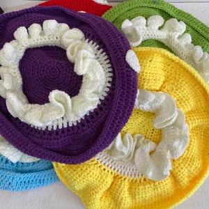 Dettaglio di berretti a fungo all'uncinetto fatti a mano in vari colori con bordi ondulati