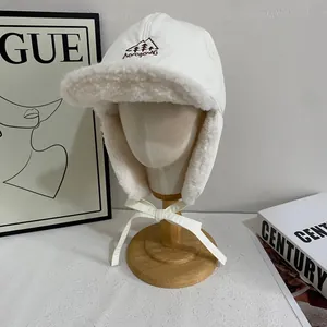 Detail of winter trapper hat featuring white windproof fabric and thick fleece ear flaps