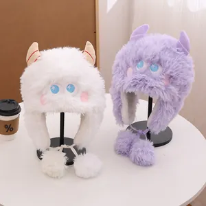 Dettaglio di cappelli mostro in peluche crema e viola con paraorecchie e pompon