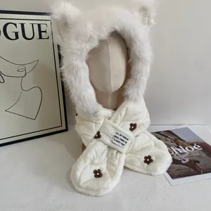 Detail of white plush hooded scarf with bear ears and flower embroidery on the quilted fabric