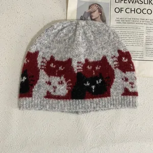 Detailed knit texture of light grey beanie with colorful cat jacquard and ribbed cuff