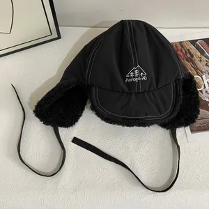 Detail of winter trapper hat with warm faux fur lining and mountain embroidery