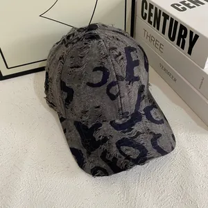 Close-up of vintage distressed baseball cap with frayed edges and abstract letter prints