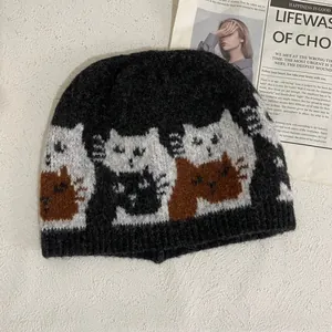 Detailed macro view of the knitted cat pattern and thick wool texture on this black beanie