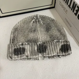 Détails du bonnet en maille délavée avec fils chinés gris et blancs et finitions usées