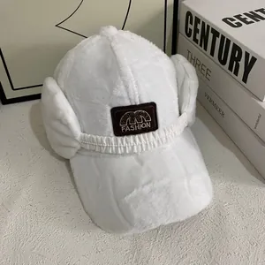 Close-up of white plush baseball cap with fuzzy earflaps and fashion embroidery