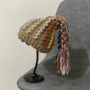 Handmade brown knit beanie with colorful decorative stitching and long tassels on top