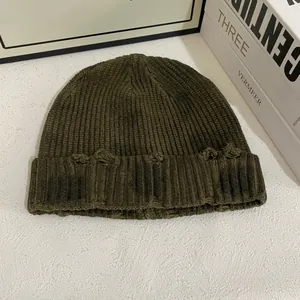 Détail d'un bonnet en maille côtelée vert armée avec texture usée pour un style urbain