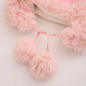 Détail du bonnet d'hiver rose en fausse fourrure de lapin avec pompons et doublure