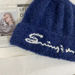 Primer plano del gorro de punto azul marino con textura suave y bordado artesanal