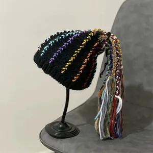 Fashionable black knit beanie with colorful braided dreadlocks and bohemian fringe detail