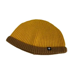 Two-tone yellow and brown knit beanie cap with cuff and snowflake patch for winter wear