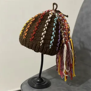 Detailed view of handmade brown knit hat featuring colorful yarn dreadlocks and long tassels