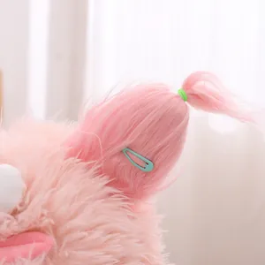 Détail du chapeau en peluche rose avec pince bleue et élastique vert fluorescent