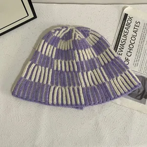 Close-up of violet and cream hand-knitted striped bucket hat on a vintage background