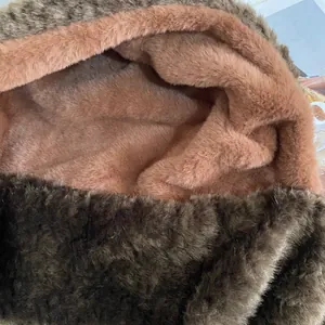 Detailansicht von dunkelbraunem Kunstfell und rosa Plüschfutter der warmen Wintermütze