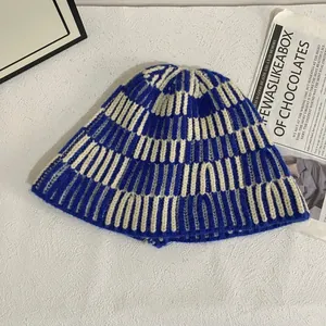 Detail of blue and beige striped knit bucket hat showing soft woolen texture and weave