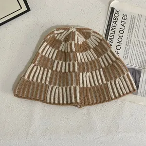 Detailed close-up of khaki and white checkerboard knit pattern on winter bucket hat