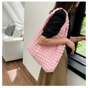 Detailed texture of pink bubble pleat tote bag showing the high-capacity design on a model