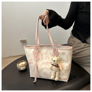 Dettaglio della borsa tote in PU con motivi graffiti rosa e un ciondolo a forma di orsetto