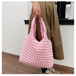 Detailed close-up of light pink popcorn fabric texture on a soft shoulder tote bag