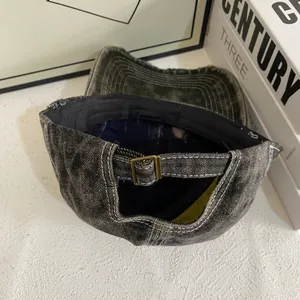 Detail of adjustable metal buckle and distressed denim texture on vintage baseball cap