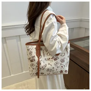 Dettaglio della borsa tote grande in PU con stampe graffiti e manici in pelle marrone