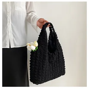 Detail of black bubble textured fabric and pleated design on a large shoulder tote bag