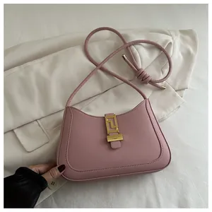 Pink leather underarm bag featuring a modern gold geometric clasp and knotted strap detail