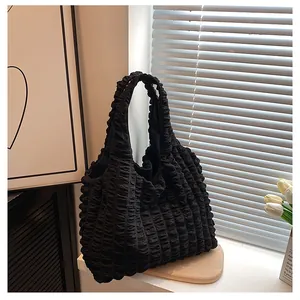 Detail of black pleated bubble fabric texture on a stylish minimalist shoulder tote bag