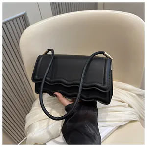 Dettaglio borsa a spalla in PU nero con bordo a onde e raffinati componenti in metallo dorato