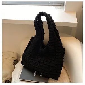 Detail of black pleated bubble texture fabric on a large capacity shoulder tote bag