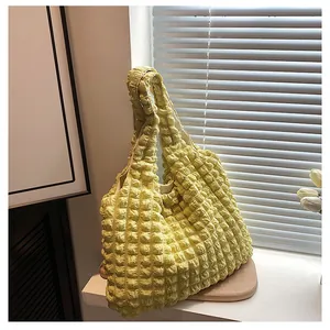 Detail of light yellow quilted tote bag with unique bubble texture and spacious design