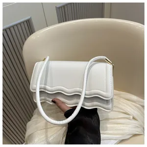 Dettaglio borsa bianca in pelle PU con patta smerlata elegante e finiture dorate