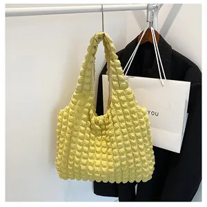 Detailed close-up of light yellow popcorn bubble texture fabric on a large tote shoulder bag